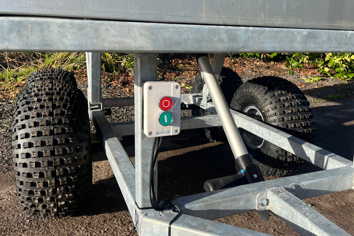 Control panel with a red and  agreen buttons fixed to the trailer chassis base.