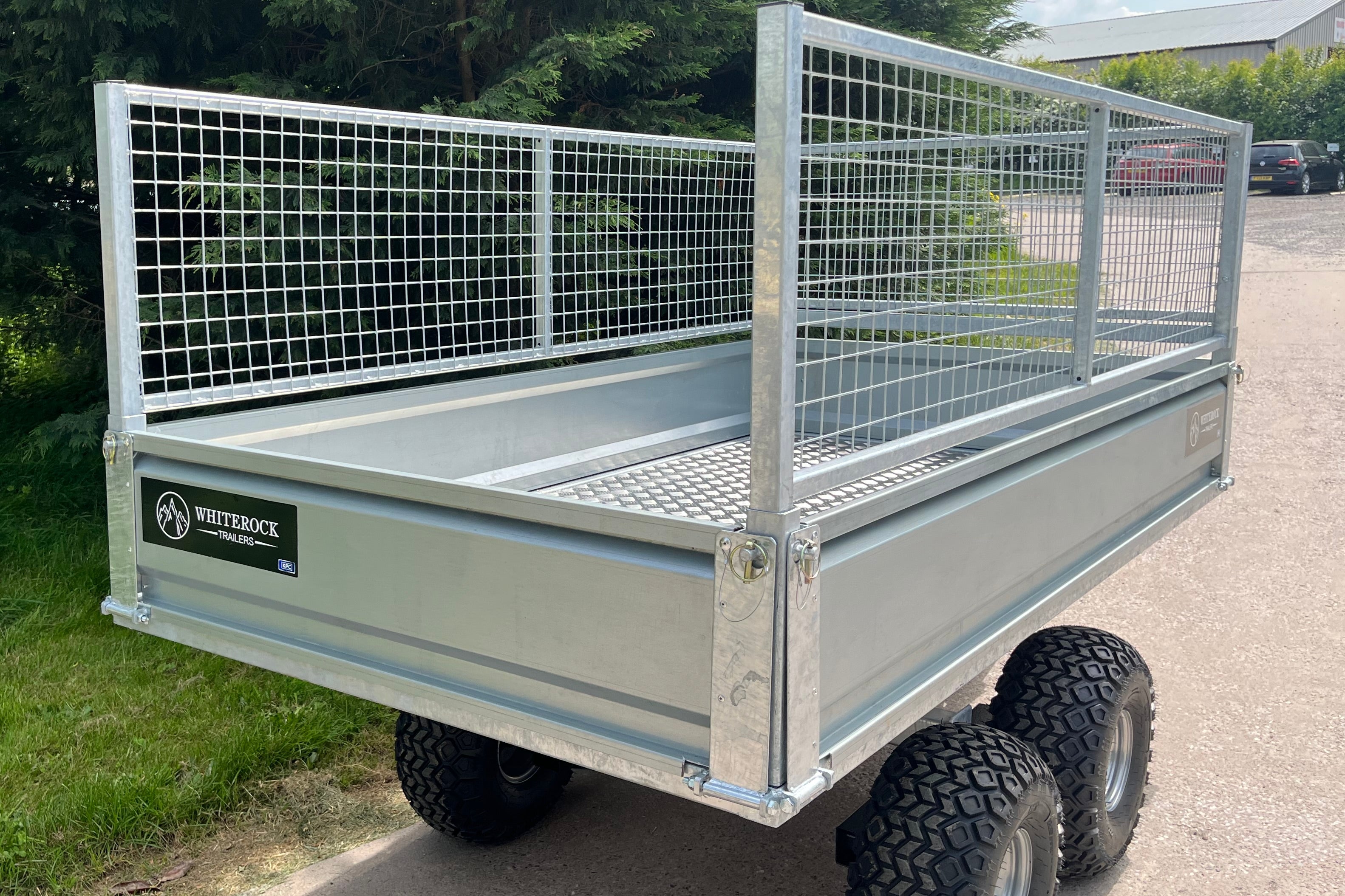 Rear view of a galvanised steel trailer with mesh sides and aluminium checkerplate flooring.