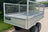 Rear view of a galvanised steel trailer with mesh sides and aluminium checkerplate flooring.