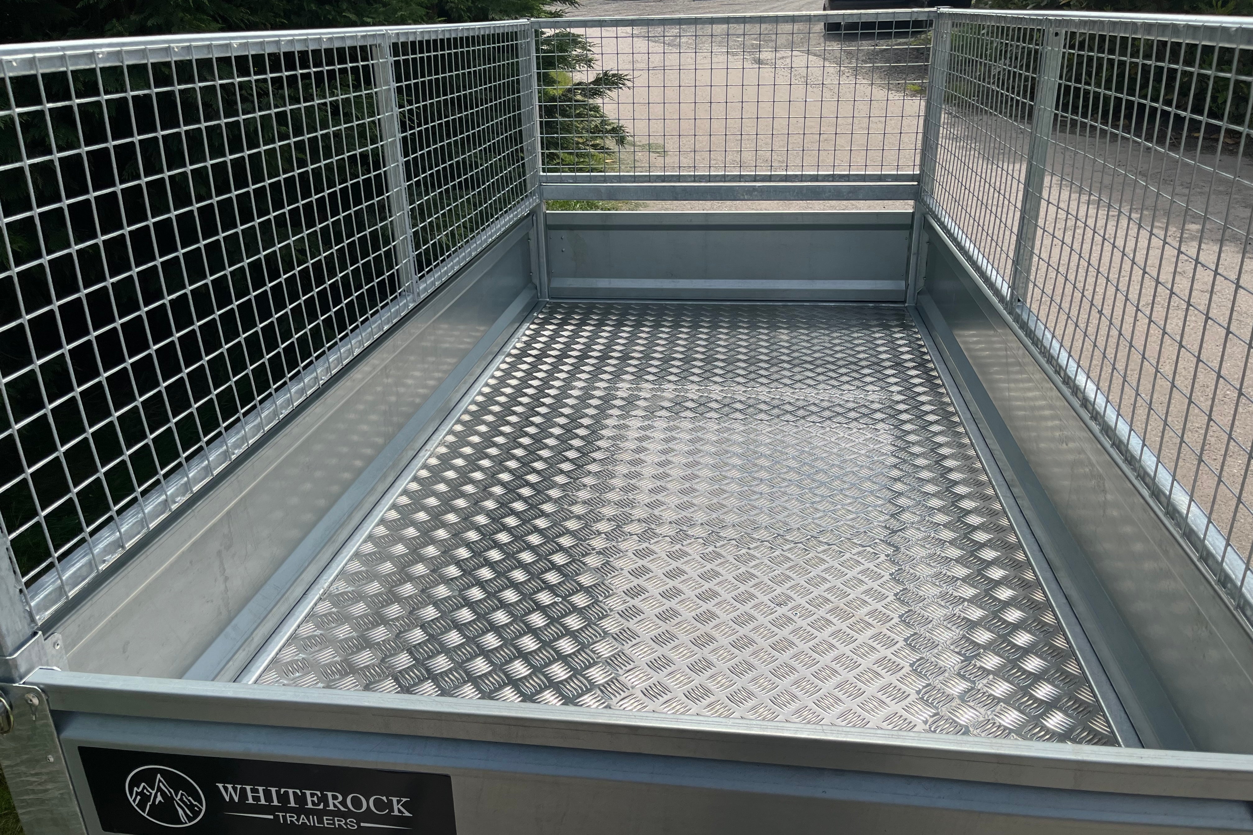 Inside view of a mesh sided trailer showing the checkerplate aluminium floor.