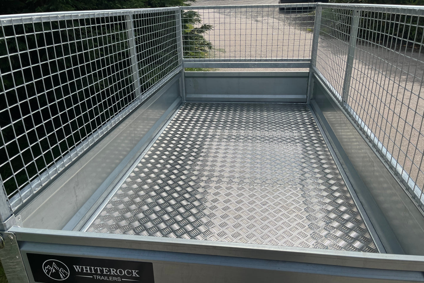 Inside view of a mesh sided trailer showing the checkerplate aluminium floor.