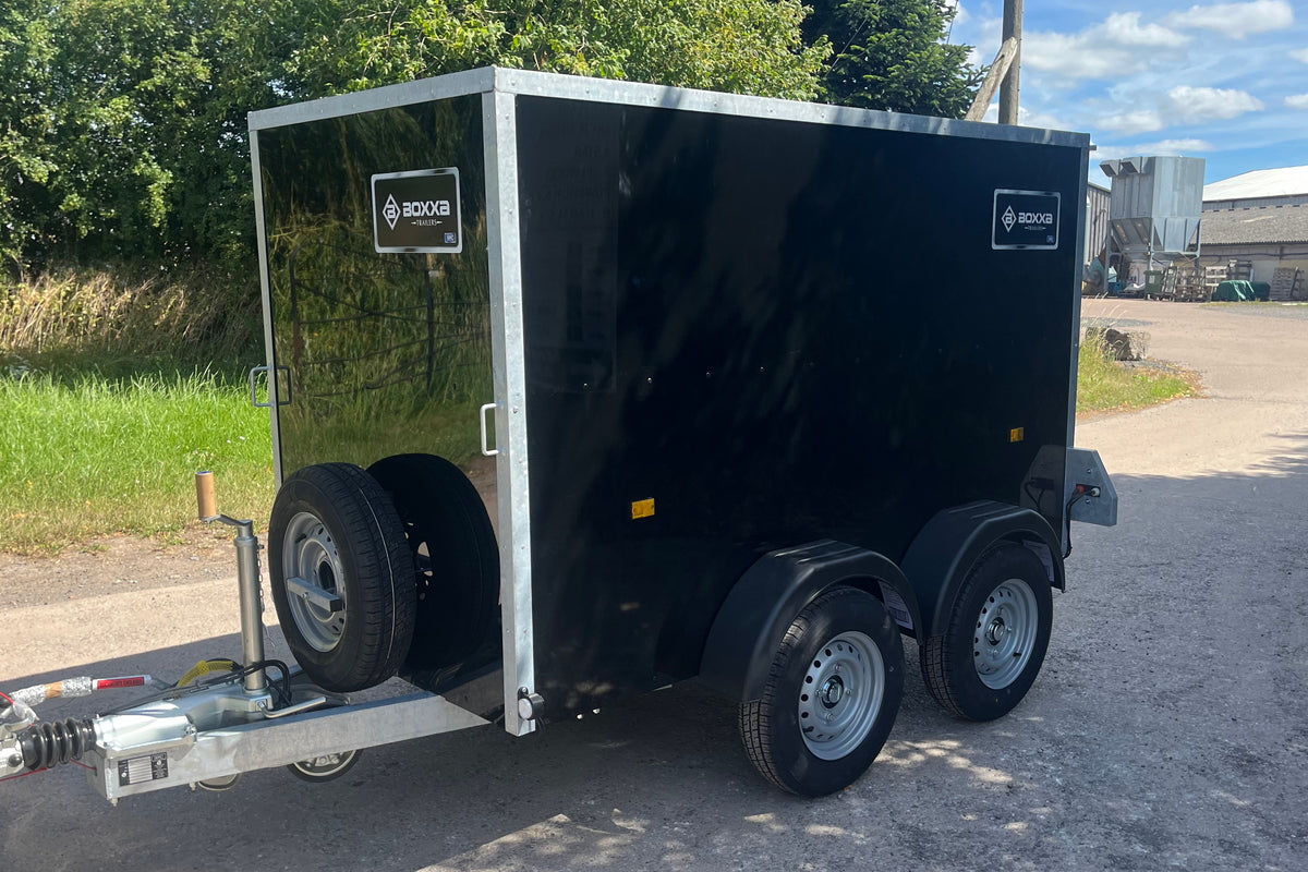 Front and side view of a twin axle black boxxa. It has a jockey wheel and front mounted spare wheel.