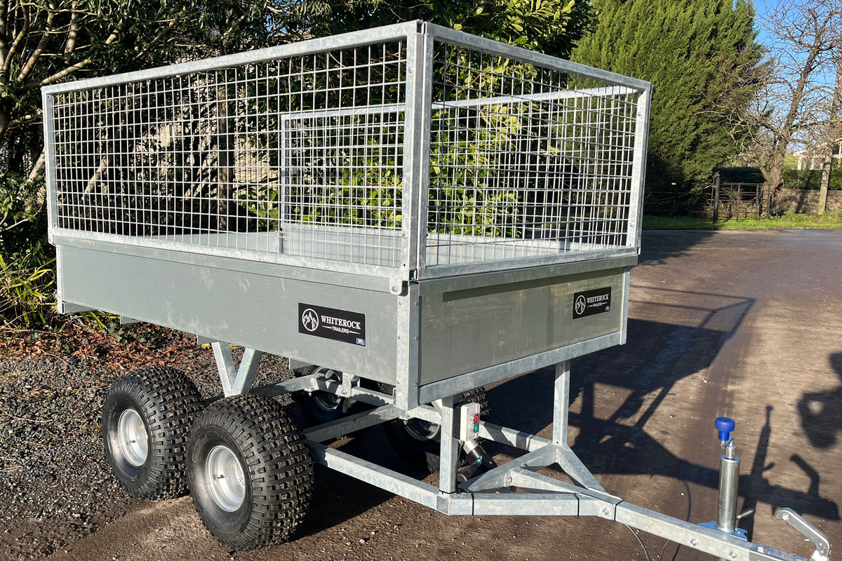 Angled view of galvanised steel trailer with mesh sides .