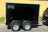 full side view ion a black twin axle Boxxa with 2 of the 4 wheels visible and the boxxa branding on the top left of the trailer body.