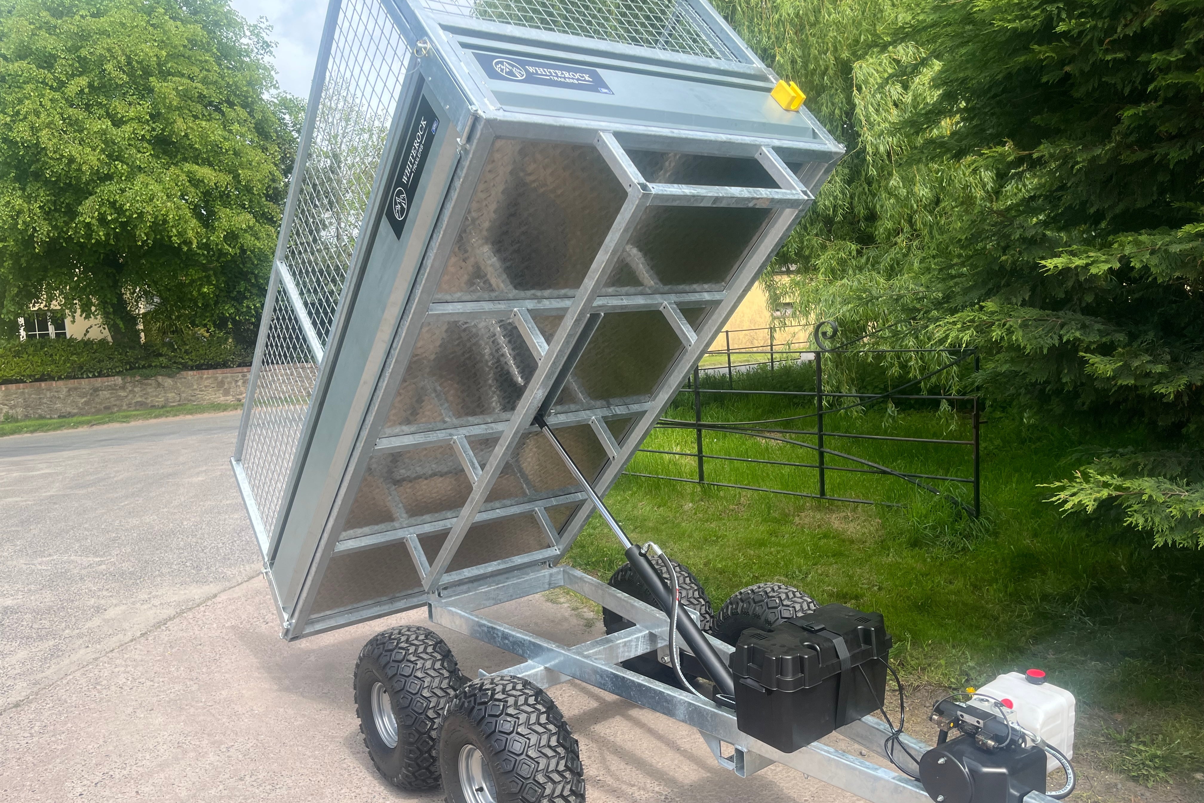 Front view of a galvanised steel trailer in full tipping position.