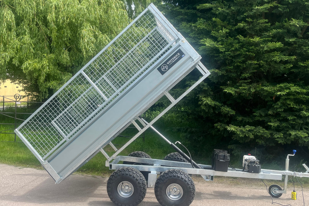 Side view of a tipping trailer with mesh sides in full tipping position.