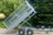 Side view of a tipping trailer with mesh sides in full tipping position.