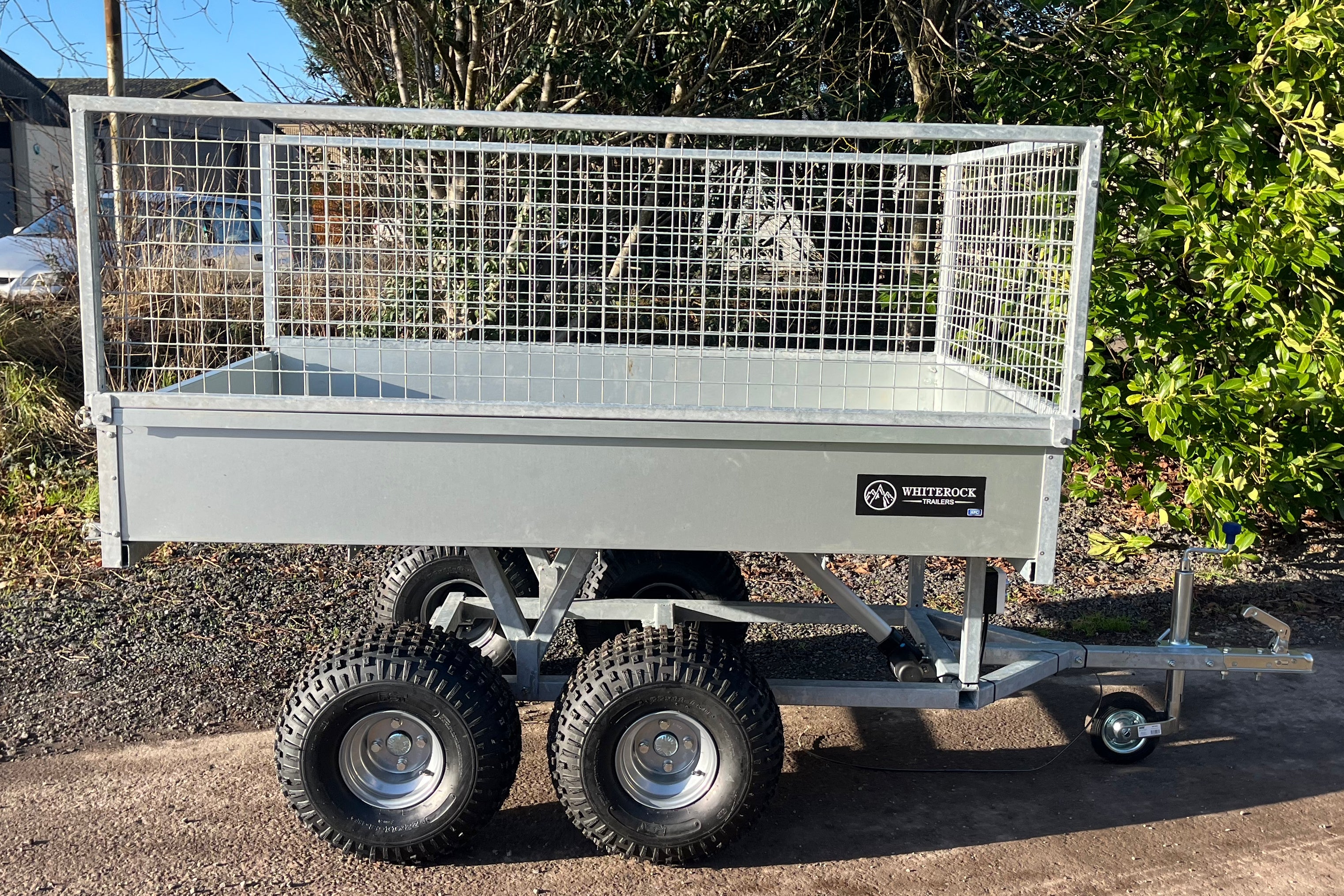 Full side view of a galvanised 4 wheeled trailer with mesh sides