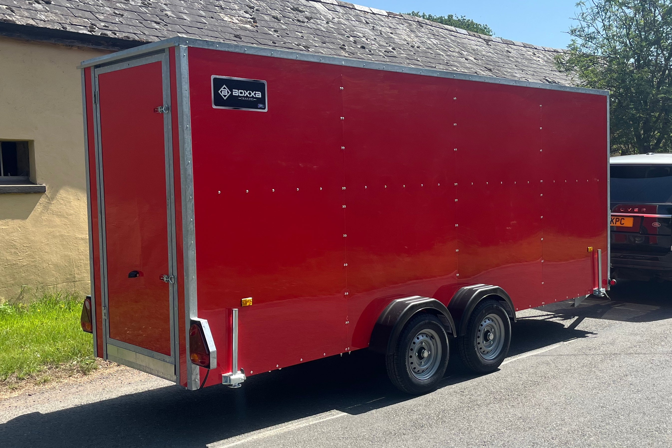 side view of a red twin axle enclosed van trailer