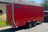 side view of a red twin axle enclosed van trailer