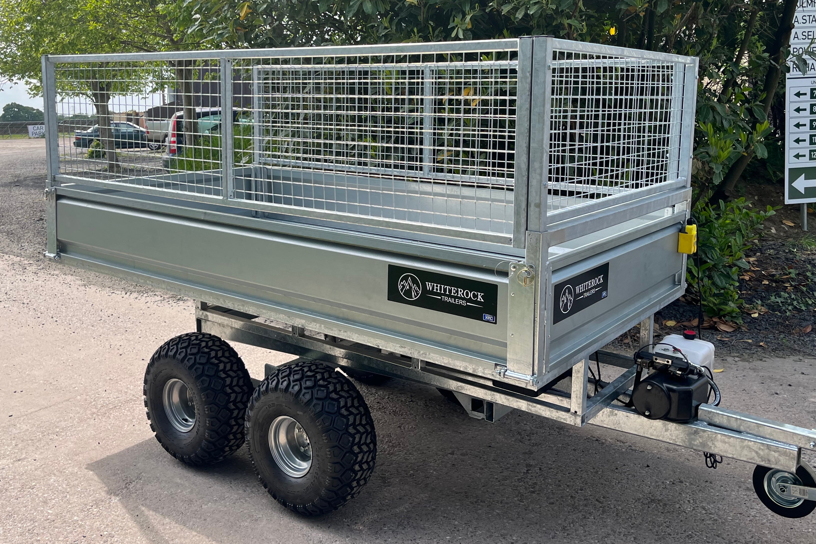 Side view of a twin axle mesh sided trailer.
