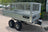 Side view of a twin axle mesh sided trailer.