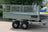 Galvanised steel trailer with mesh sides and twin axle. Jockey wheel is in the up position at the front of the trailer.