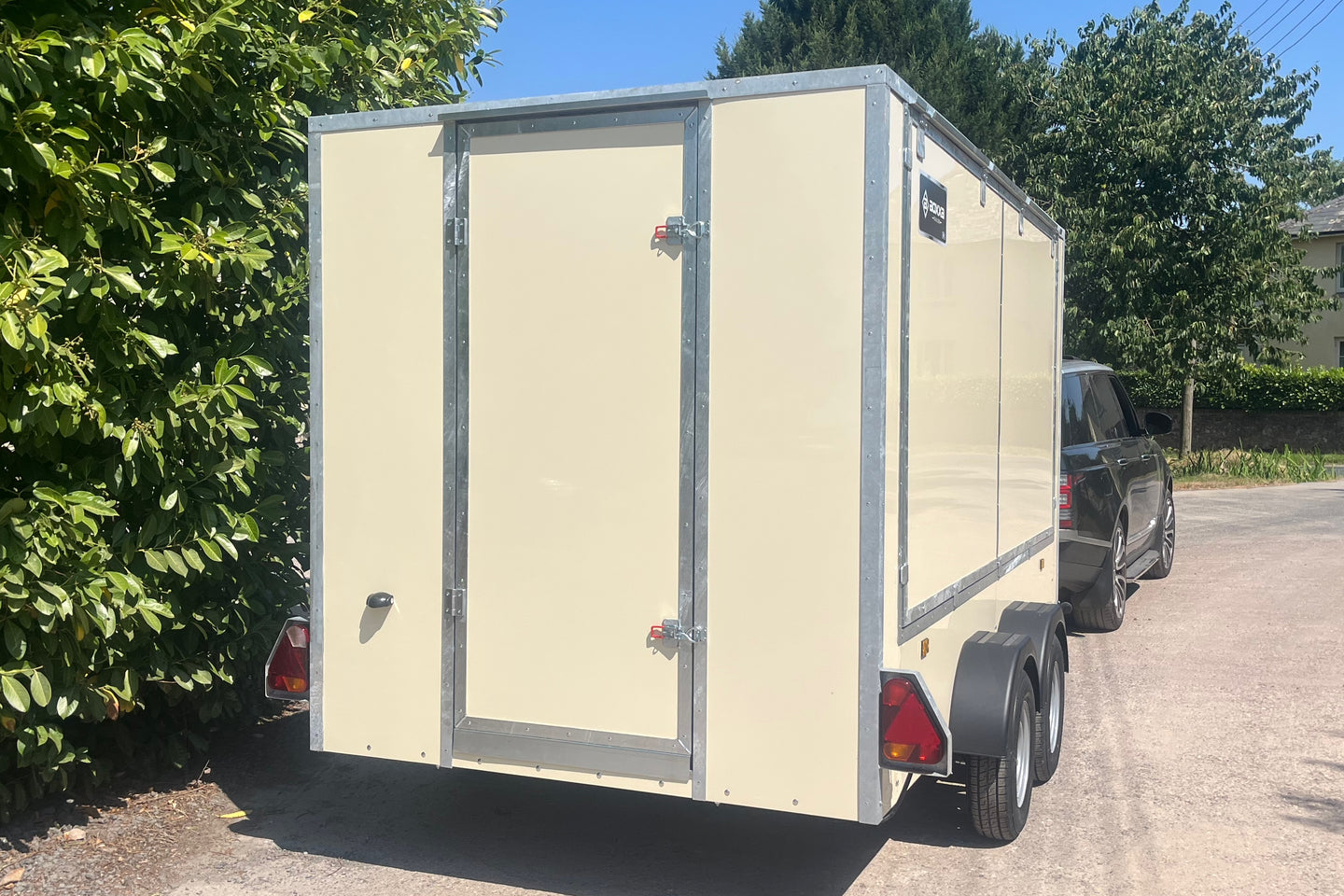 Rear view of an ivory coloured enclosed trailer showing a rear door