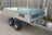 Front view of a flatbed tipping trailer with tipping mechanism mounted.