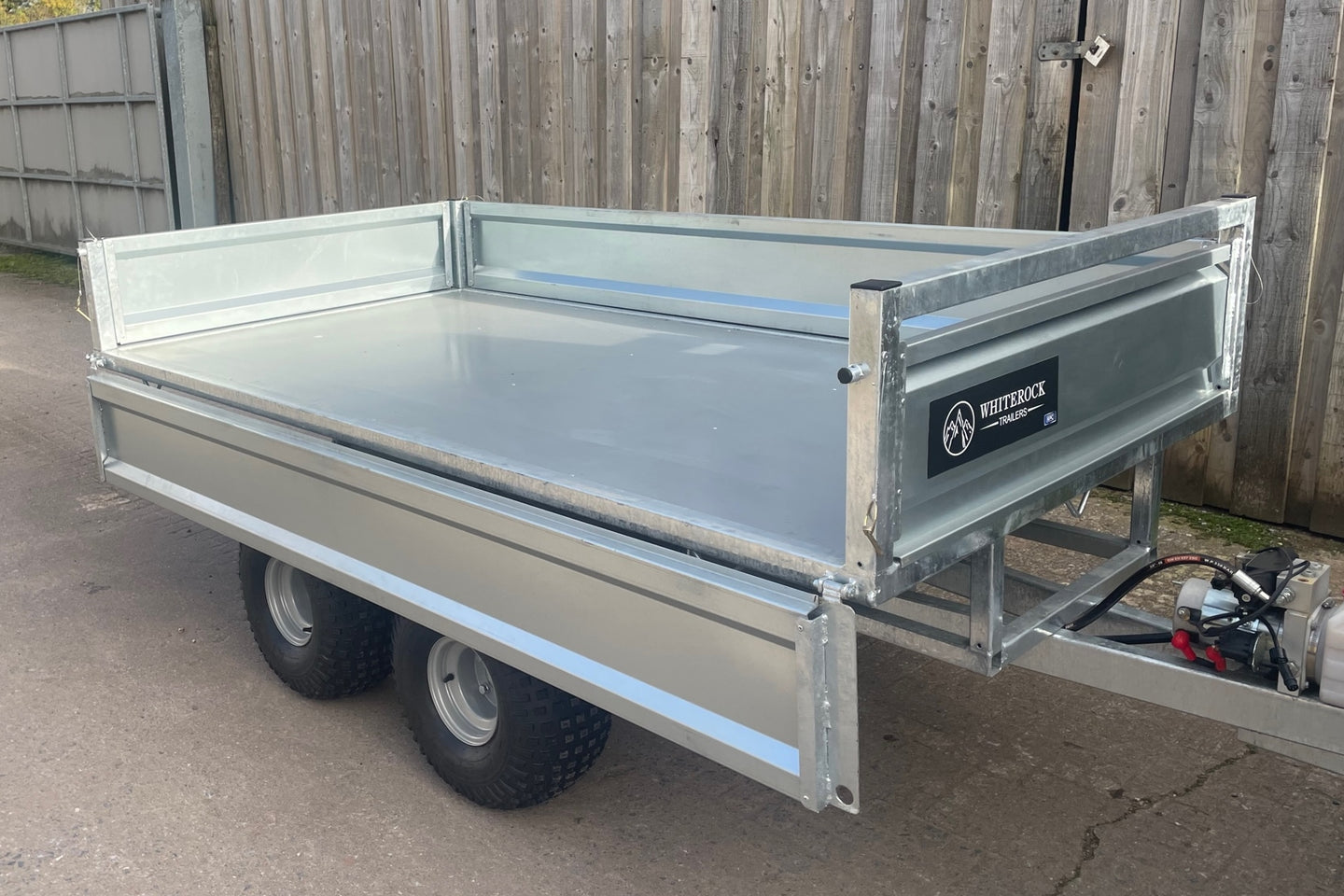 Side view of galvanised steel trailer with one side lowered down.