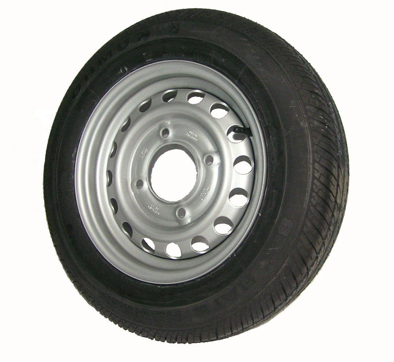 A black tire mounted on a silver steel rim, photographed against a plain white background.